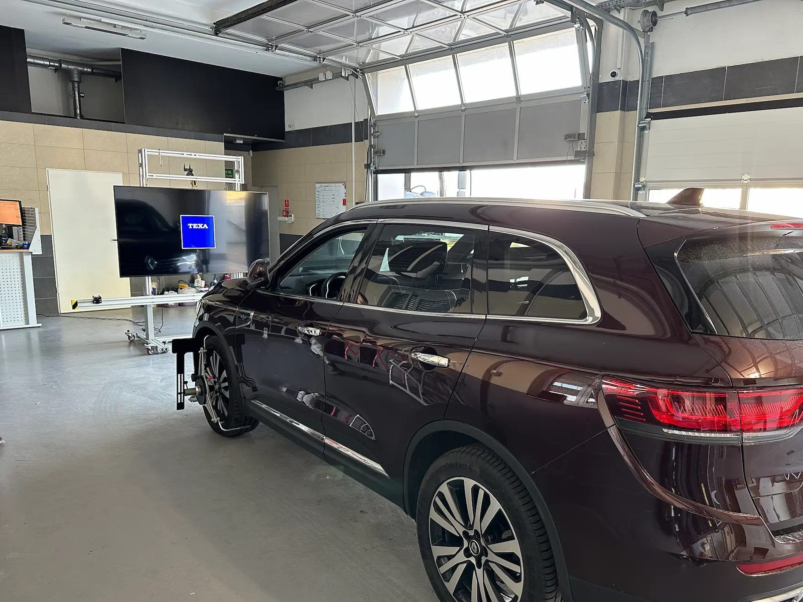 Kalibracja kamery ADAS w warsztacie Szybiarzy: auto przed tablicą kalibracyjną